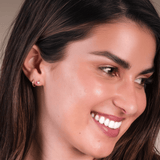 Close up of a woman wearing cubic zirconia hypoallergenic flat back stud earrings.
