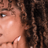 Close Up of a woman wearing cubic zirconia hypoallergenic flat back stud earrings.
