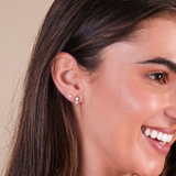 Close-up of a woman wearing earrings with a neutral background