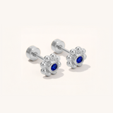 Pair of silver earrings with blue gemstones on a white background