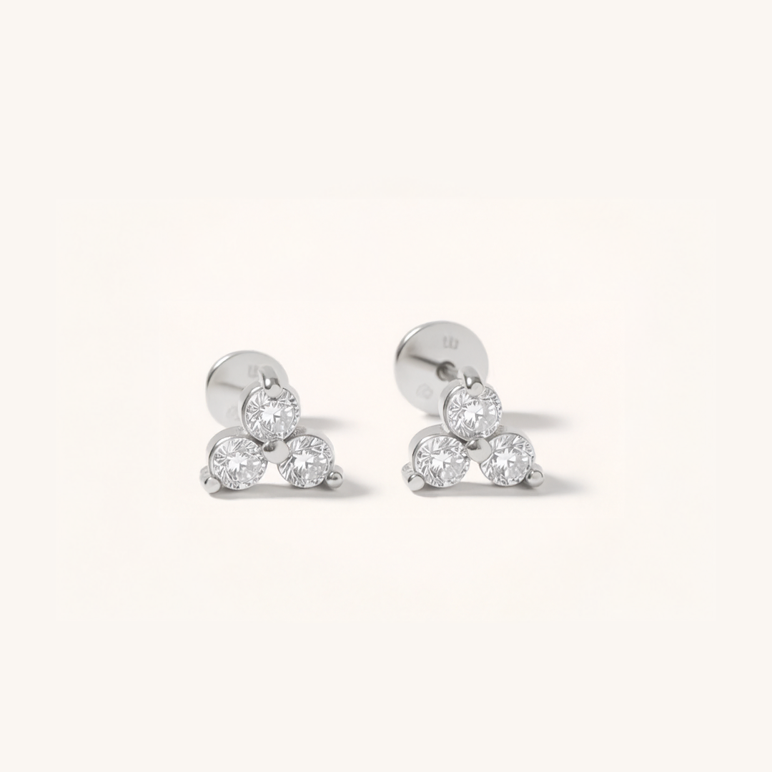 Pair of silver earrings with clear gemstones on a white background.