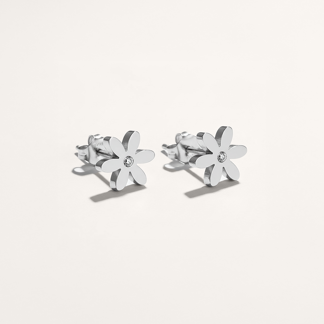 Silver flower-shaped earrings on a white background