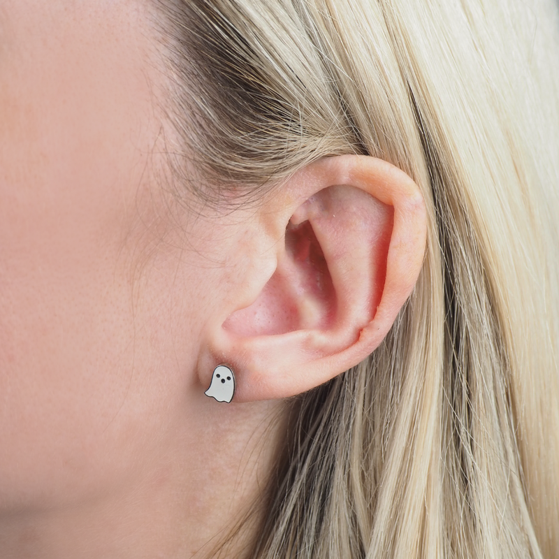 Close-up of an ear with a ghost-shaped earring.