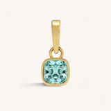 Gold pendant with an aqua gemstone on a white background.