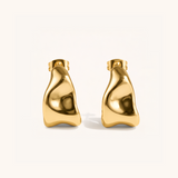 Pair of gold hoop earrings on a beige background