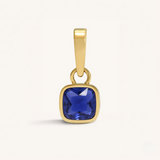 Gold pendant with a blue gemstone on a white background