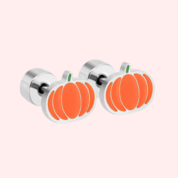 A silver pair of orange pumpkin earrings on a light pink background.