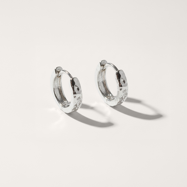Silver hoop earrings on a light gray background