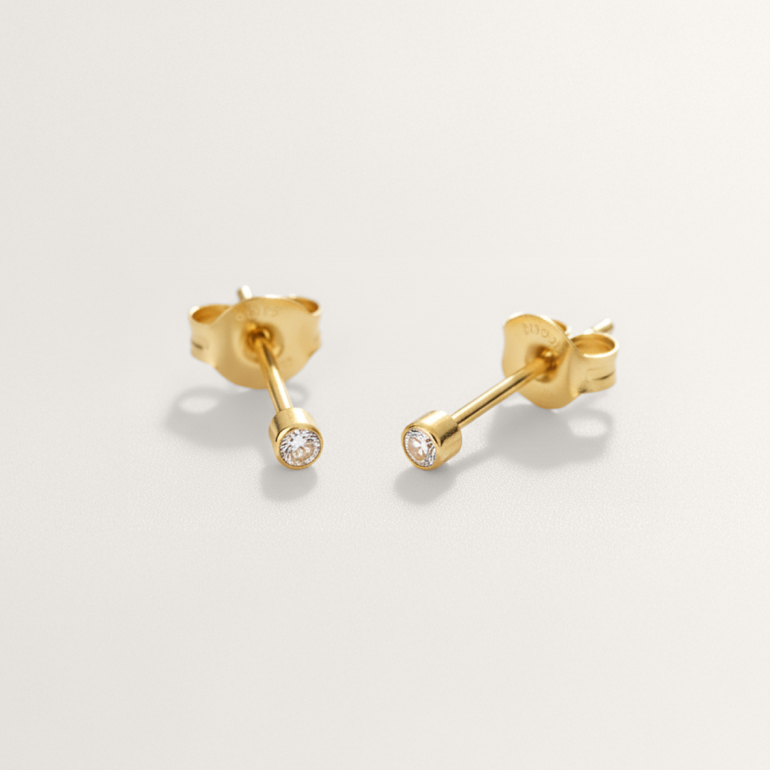 Mini CZ hypoallergenic stud earrings in gold on white background
