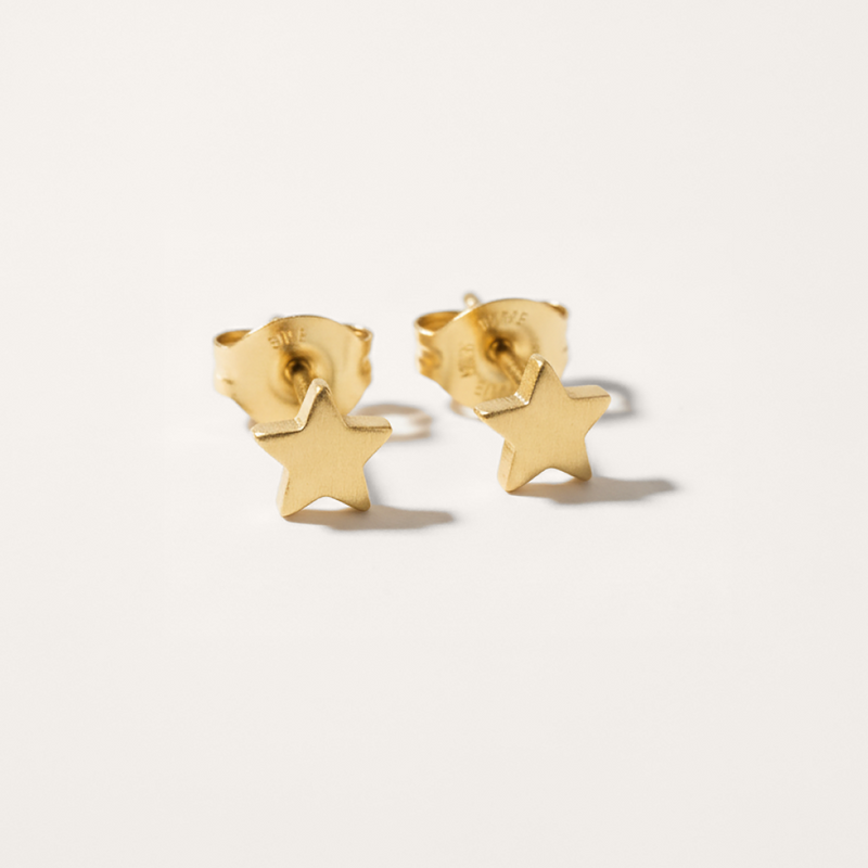 Mini star hypoallergenic earrings in gold on white background
