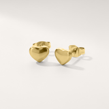 Rounded heart hypoallergenic earrings in gold on white background
