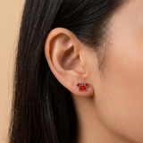 A girl wearing a pair of red crab flat back earrings.