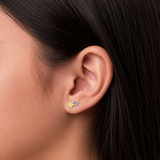 A girl wearing a pair of rainbow star flat back earrings.