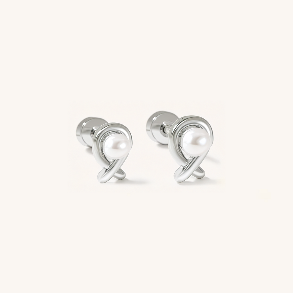 Pair of silver earrings with a central pearl on a white background.