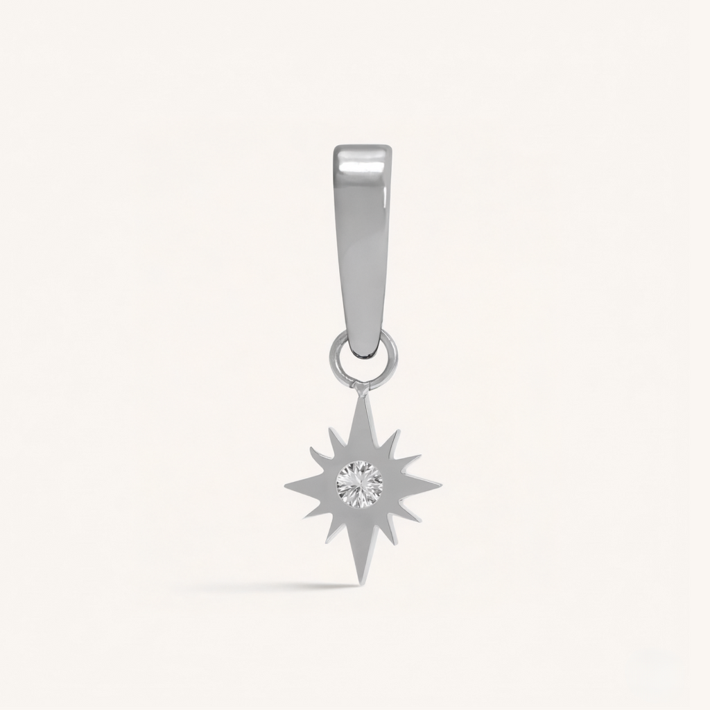 Silver star-shaped pendant with a central gemstone on a light gray background