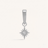 Silver star-shaped pendant with a central gemstone on a light gray background