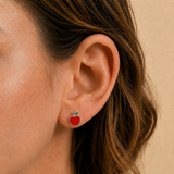 A girl wearing a red silver apple earring.