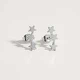 Triple star ear climber earrings in silver on white background